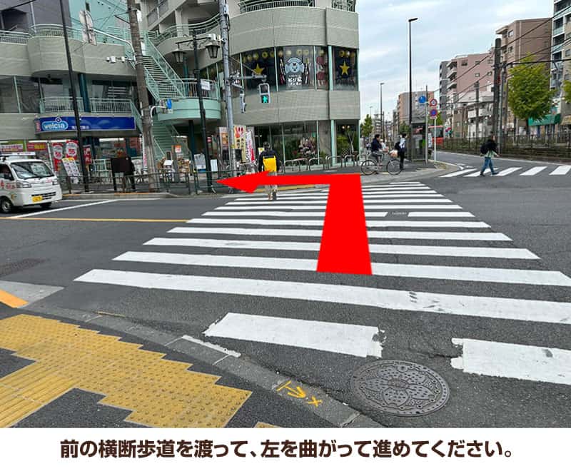 前の横断歩道を渡って、左を曲がって進めてください。